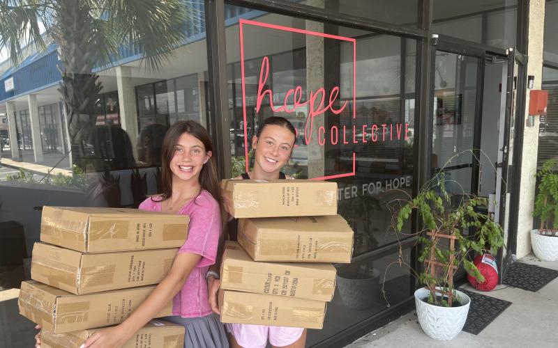 2 girls carrying boxes